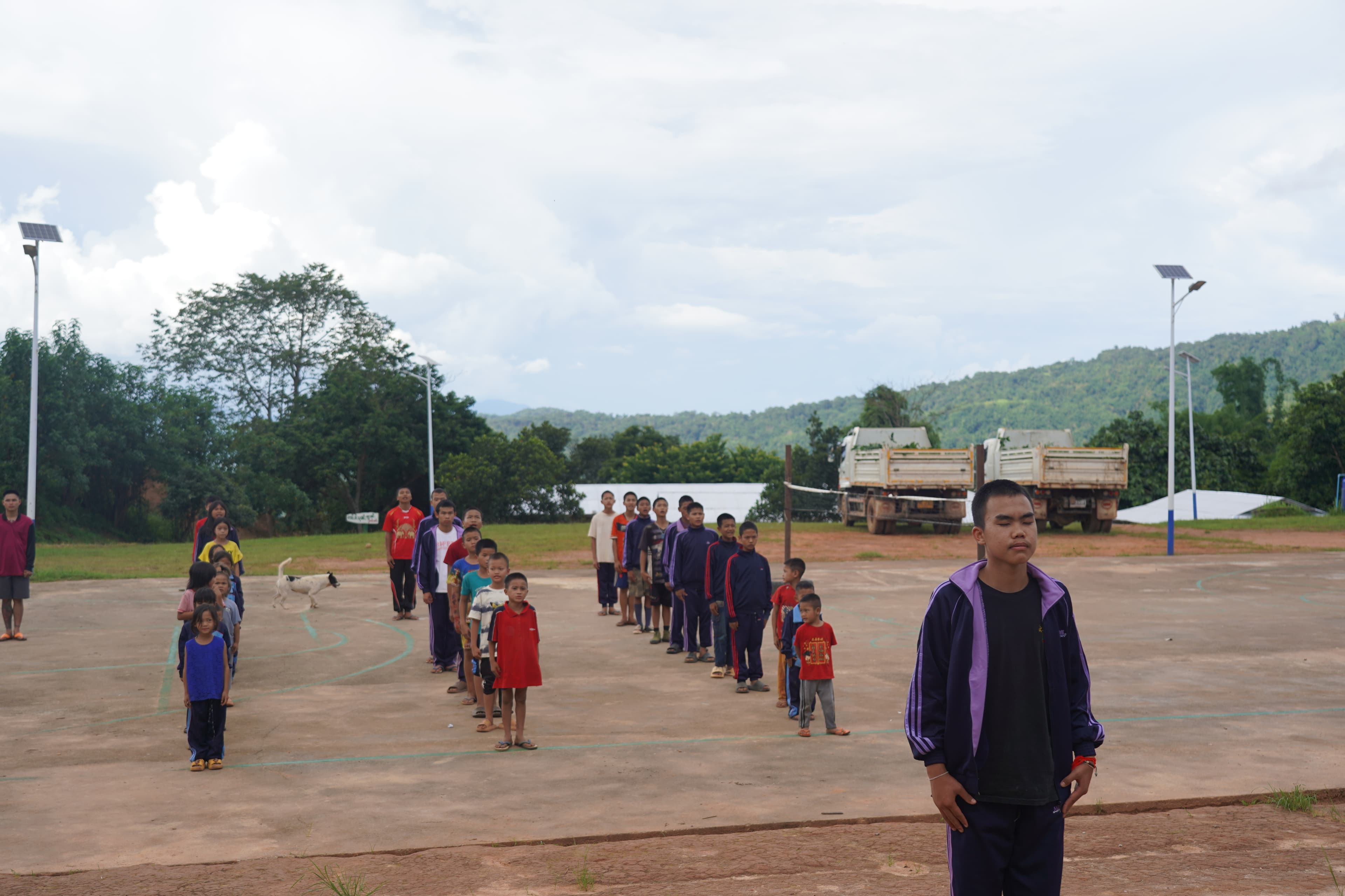 Students lining up in the schoolyard before class in a remote village